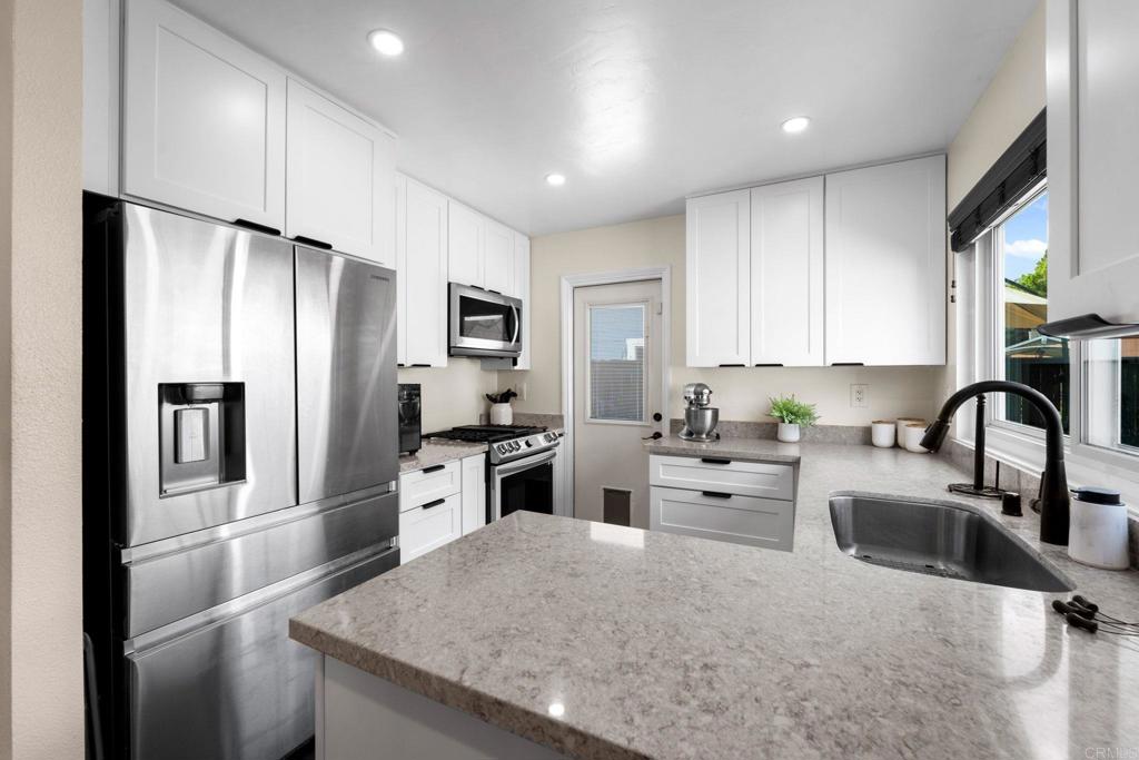 333 Sunflower Escondido, CA 92026 - Photo 5 of 36 a kitchen with white cabinets and stainless steel appliances
