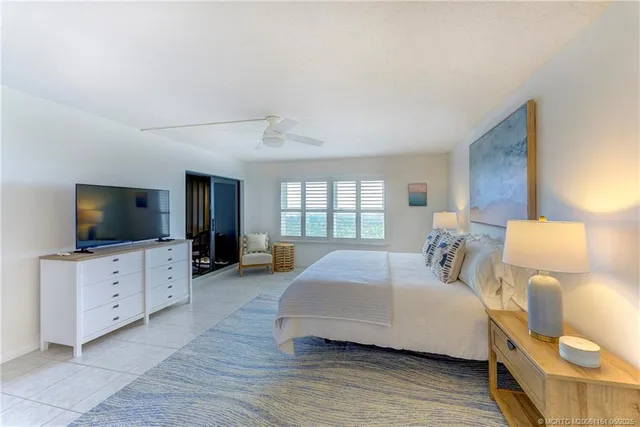 a spacious bedroom with a bed and a flat screen television
