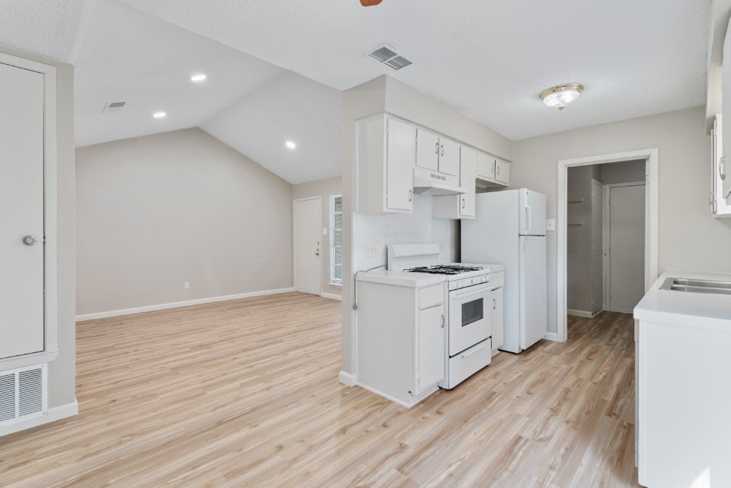 a kitchen with stainless steel appliances a white stove top oven and a refrigerator