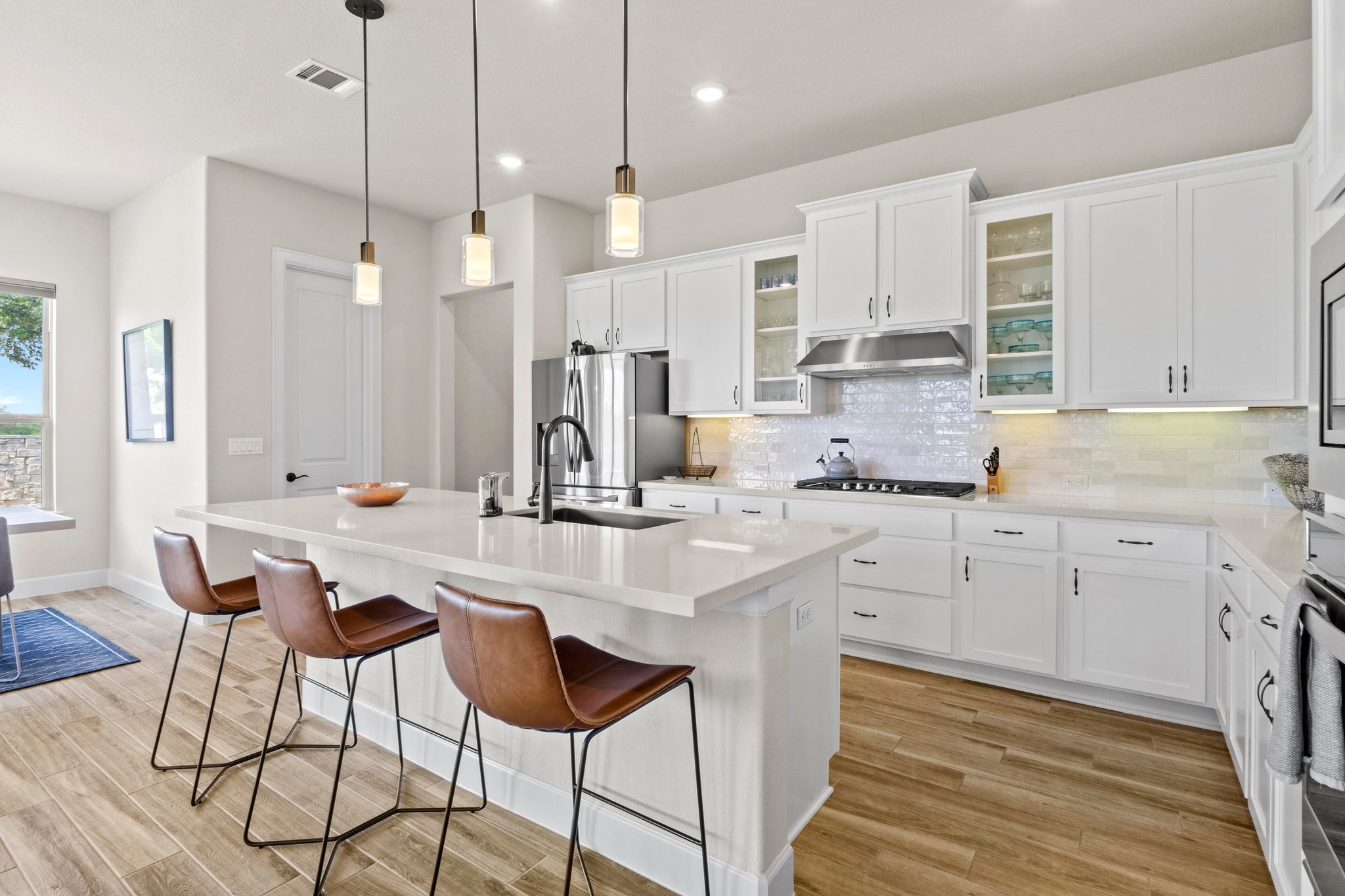 2609 Antalya Loop Leander, TX 78641 - Photo 2 of 40 a kitchen with stainless steel appliances kitchen island granite countertop a dining table chairs sink and cabinets