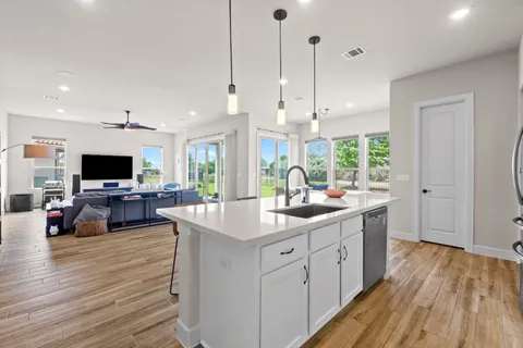 a kitchen with stainless steel appliances kitchen island granite countertop a sink stove and refrigerator