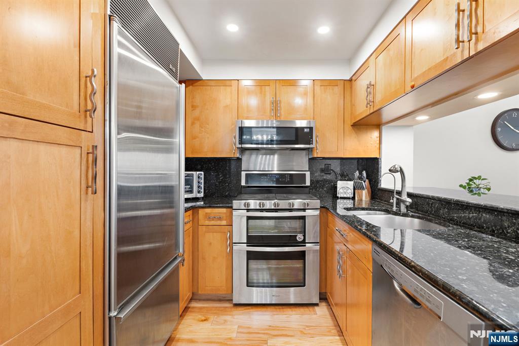 316 Nelson Court Edgewater, NJ 07020 - Photo 12 of 29 a kitchen with stainless steel appliances granite countertop a stove and a refrigerator