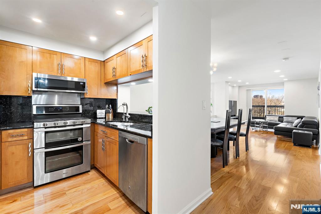 316 Nelson Court Edgewater, NJ 07020 - Photo 3 of 29 a kitchen with stainless steel appliances granite countertop a stove top oven a sink dishwasher a dining table and chairs with wooden floor