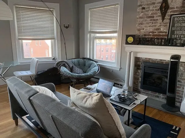 a living room with furniture a fireplace and a floor to ceiling window