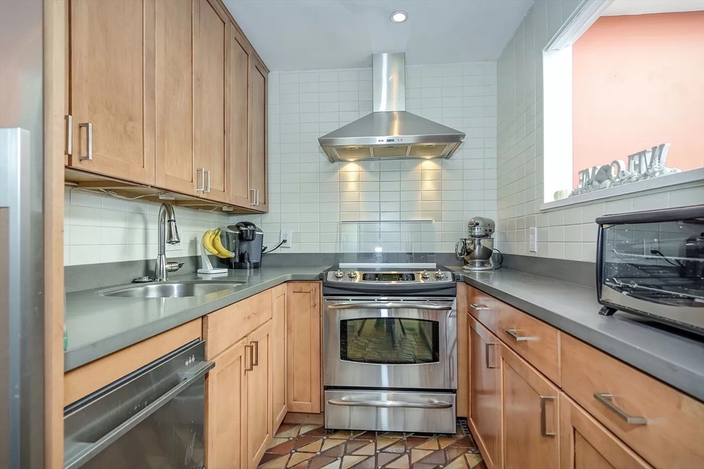 583 Massachusetts Avenue, Unit 5 Boston, MA 02118 - Photo 6 of 15 a kitchen with stainless steel appliances granite countertop a sink a stove and a wooden floors