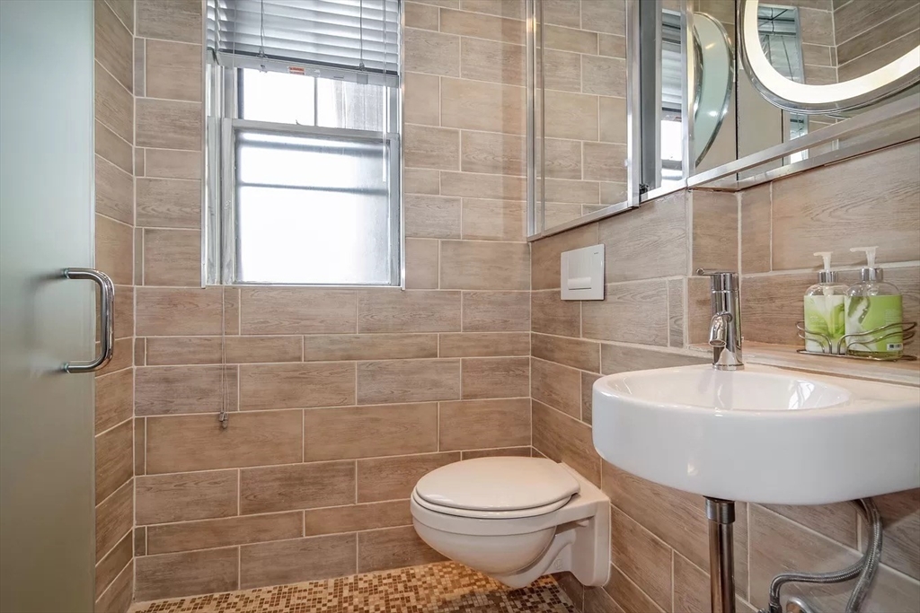 583 Massachusetts Avenue, Unit 5 Boston, MA 02118 - Photo 7 of 15 a bathroom with a sink a toilet and a mirror