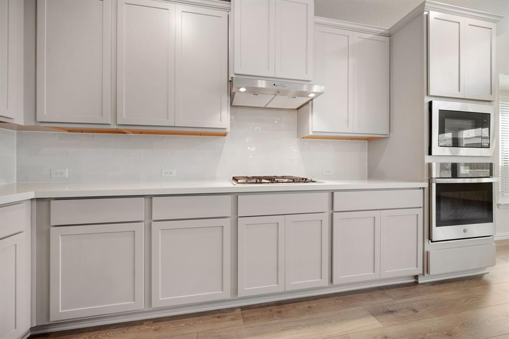 912 Alberta Spruce Road Justin, TX 76247 - Photo 11 of 35 a kitchen with white cabinets and white appliances
