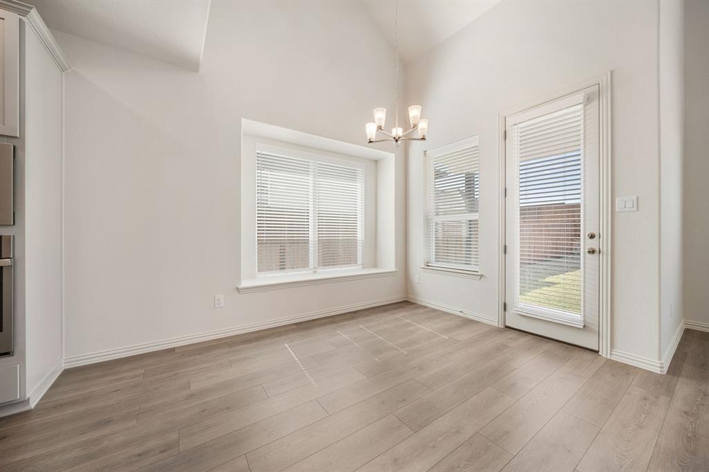912 Alberta Spruce Road Justin, TX 76247 - Photo 14 of 35 an empty room with wooden floor and windows