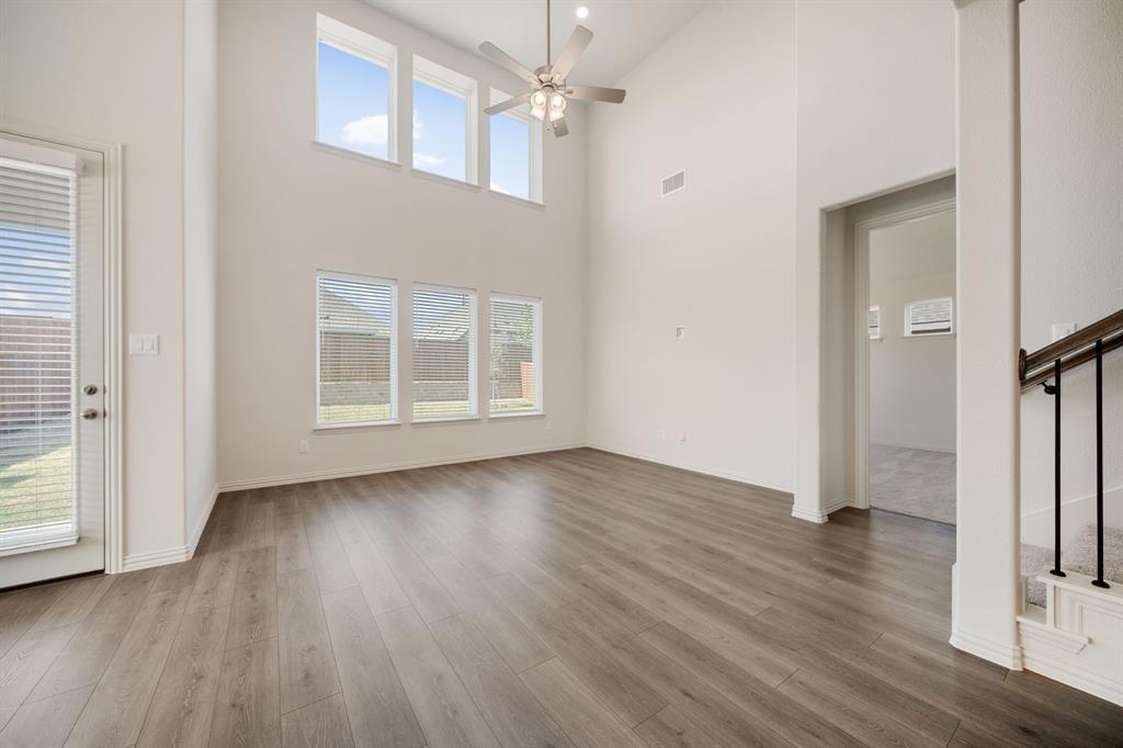 912 Alberta Spruce Road Justin, TX 76247 - Photo 15 of 35 an empty room with wooden floor front door and windows