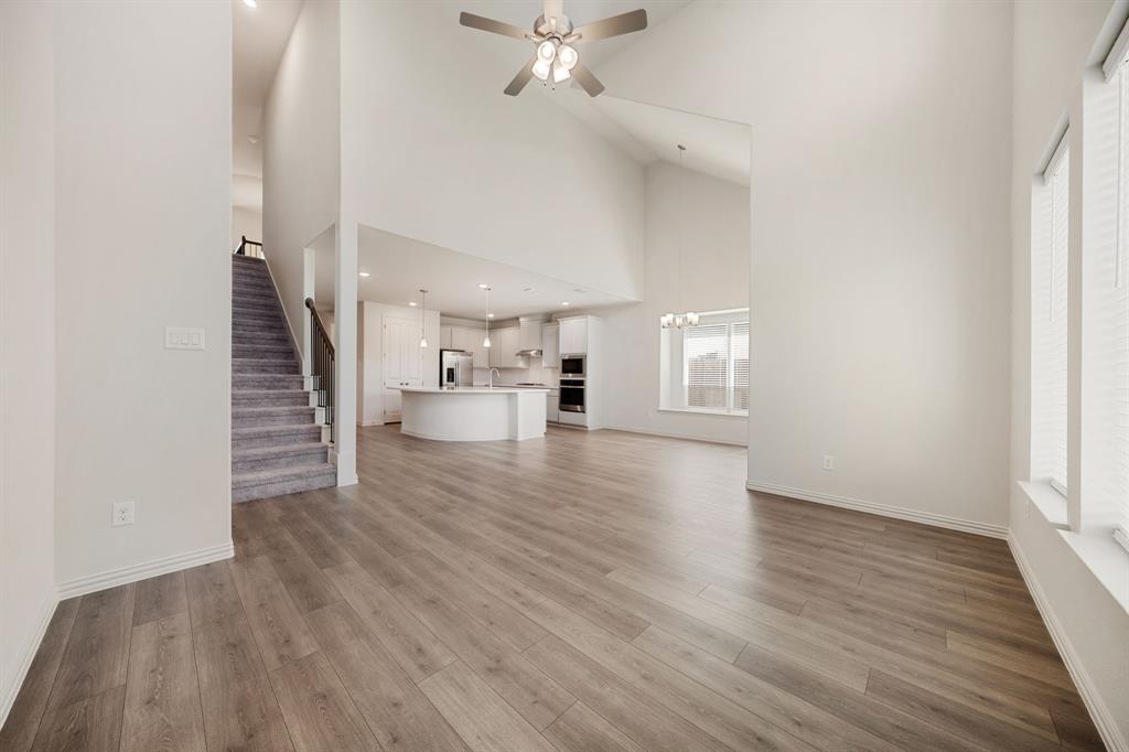 912 Alberta Spruce Road Justin, TX 76247 - Photo 16 of 35 a view of a livingroom with wooden floor and stairs