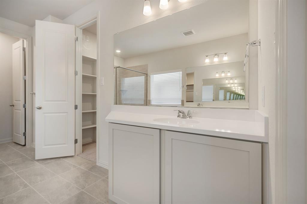 912 Alberta Spruce Road Justin, TX 76247 - Photo 21 of 35 a bathroom with a double vanity sink and mirror