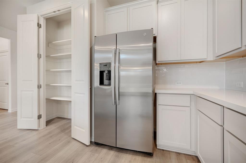 912 Alberta Spruce Road Justin, TX 76247 - Photo 10 of 35 a kitchen with a refrigerator and wooden floor