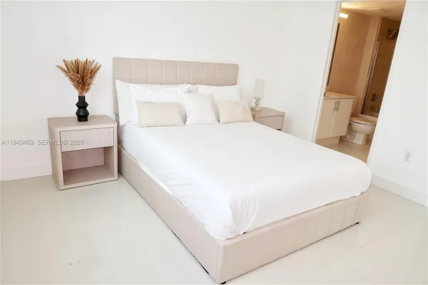 a large bed sitting in a bedroom next to a window