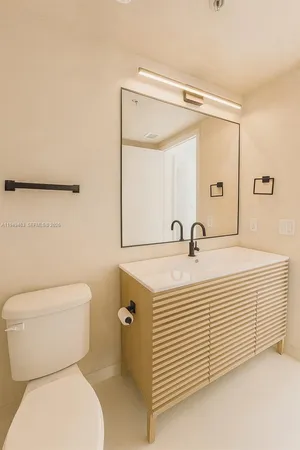 a bathroom with a sink a toilet and a mirror