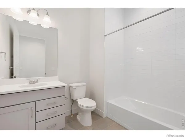 a bathroom with a toilet a sink a mirror and a bathtub