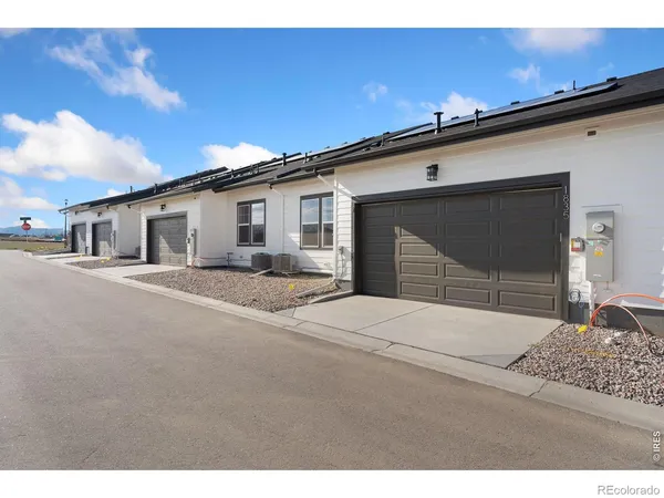a backyard of a house with garage and barbeque oven