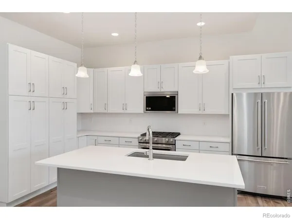 a kitchen with stainless steel appliances a refrigerator sink and microwave