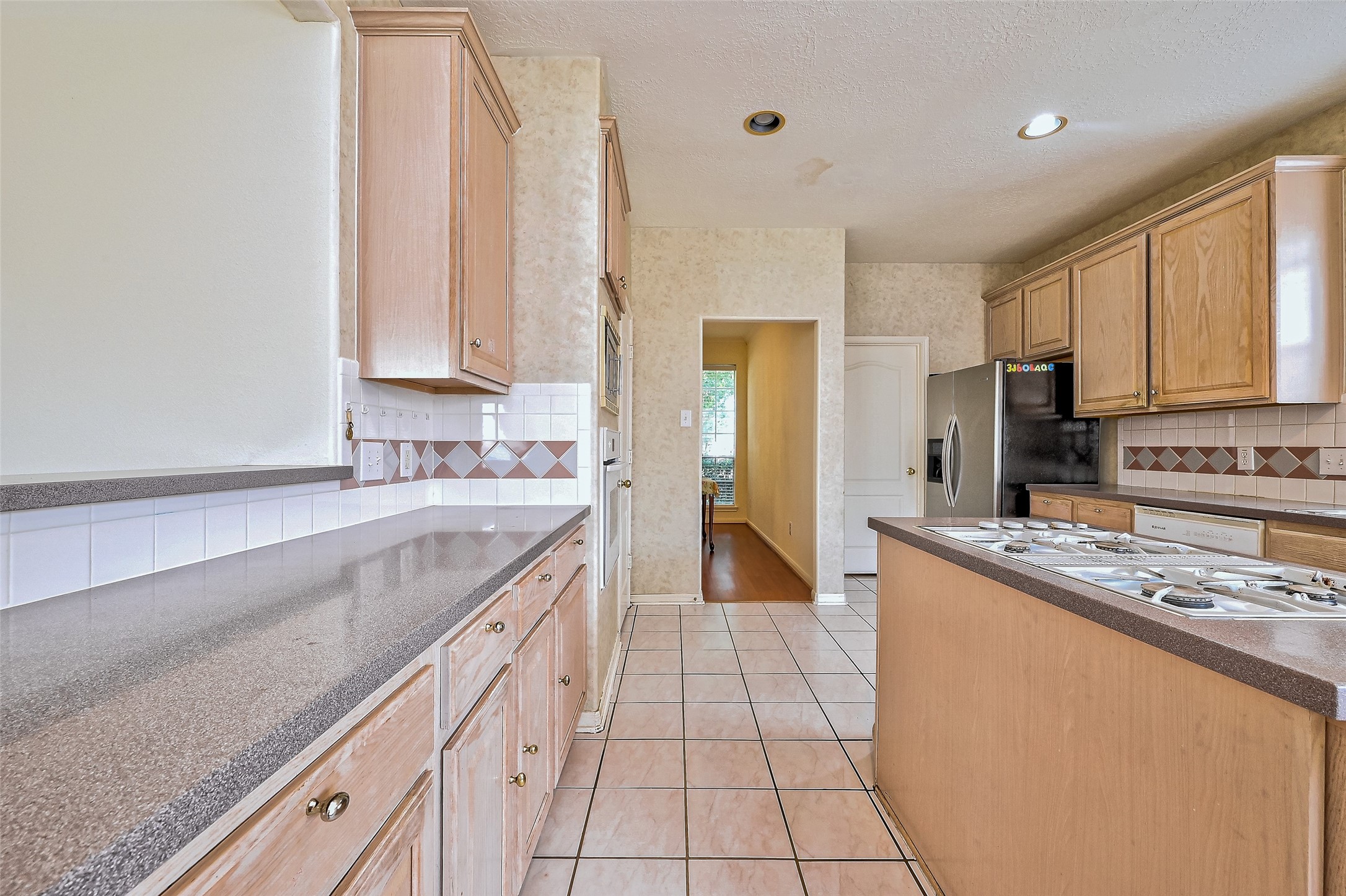 6806 Rhodes Court Missouri City, TX 77459 - Photo 20 of 50 a large kitchen with stainless steel appliances granite countertop a stove a sink and a refrigerator