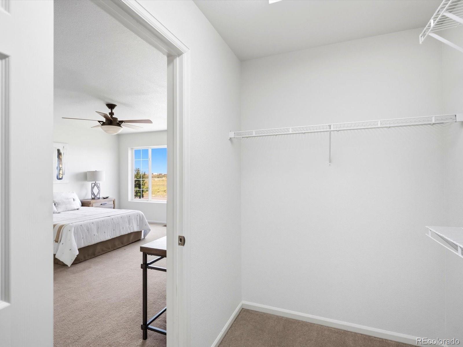 5444 Perth Court Denver, CO 80249 - Photo 30 of 46 a bedroom with a bed and a chandelier