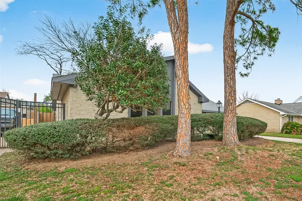 a view of a house with backyard and trees