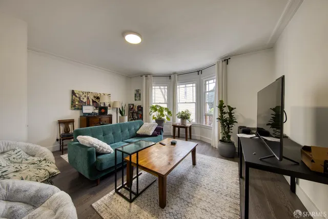 a living room with furniture a rug and a flat screen tv