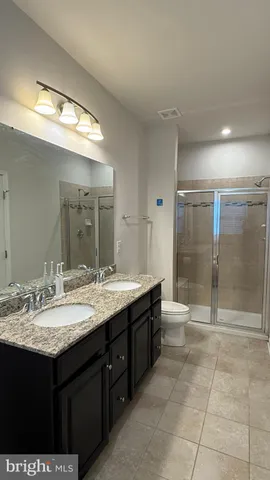 a bathroom with a granite countertop sink mirror and shower