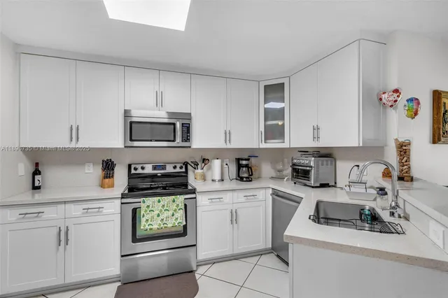 a kitchen with cabinets appliances a sink and a counter top space