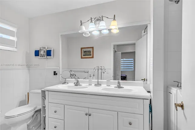 a bathroom with a toilet a sink and mirror