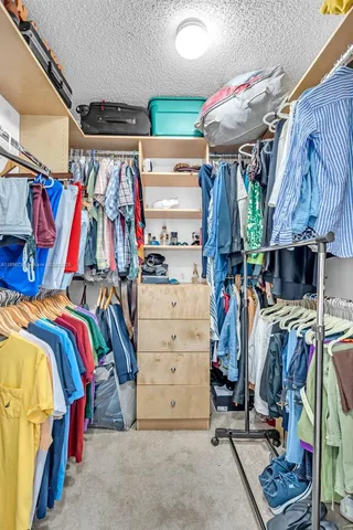 a view of walk in closet with clothes