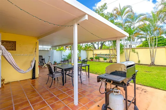a view of a patio with a table chairs and a backyard