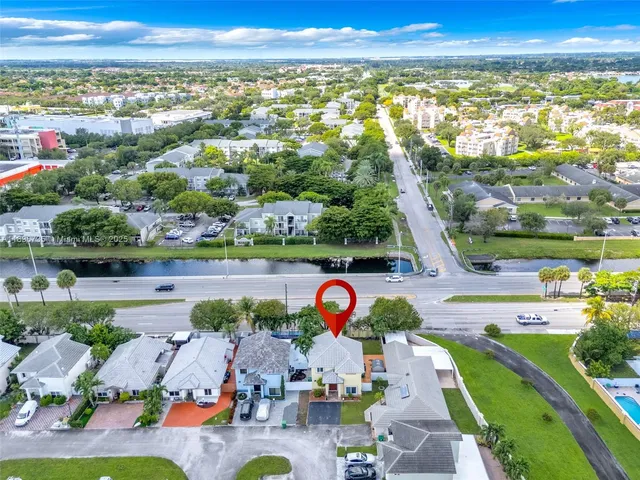 an aerial view of residential houses with outdoor space and swimming pool