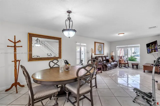 a view of a dining room and livingroom with furniture wooden floor a rug and a painting