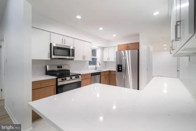 a large kitchen with stainless steel appliances granite countertop a sink and a stove