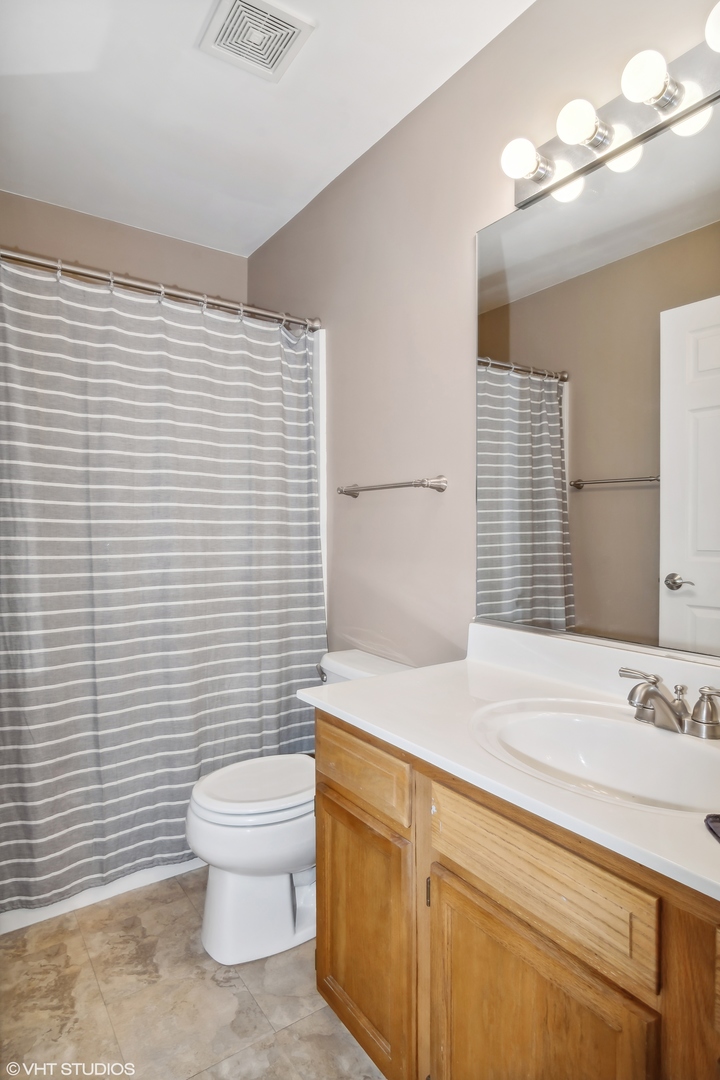 1545 Spaulding Road Bartlett, IL 60103 - Photo 15 of 21 a bathroom with a sink a toilet and mirror