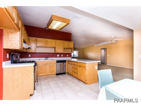 11801 Henderson Road Dewey-Humboldt, AZ 86327 - Photo 6 of 19 a kitchen with stainless steel appliances kitchen island granite countertop a sink and a stove