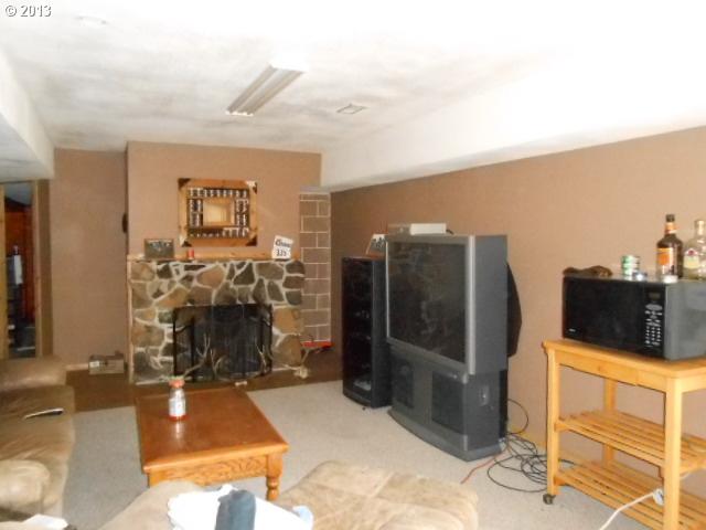 12015 South Fox Road Molalla, OR 97038 - Photo 6 of 16 a living room with furniture a flat screen tv and a fireplace