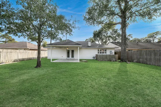 a view of a house with backyard and a tree