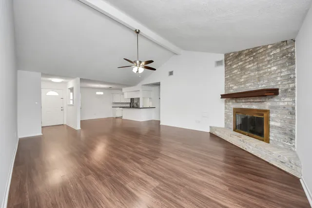 a view of empty room with wooden floor and fireplace