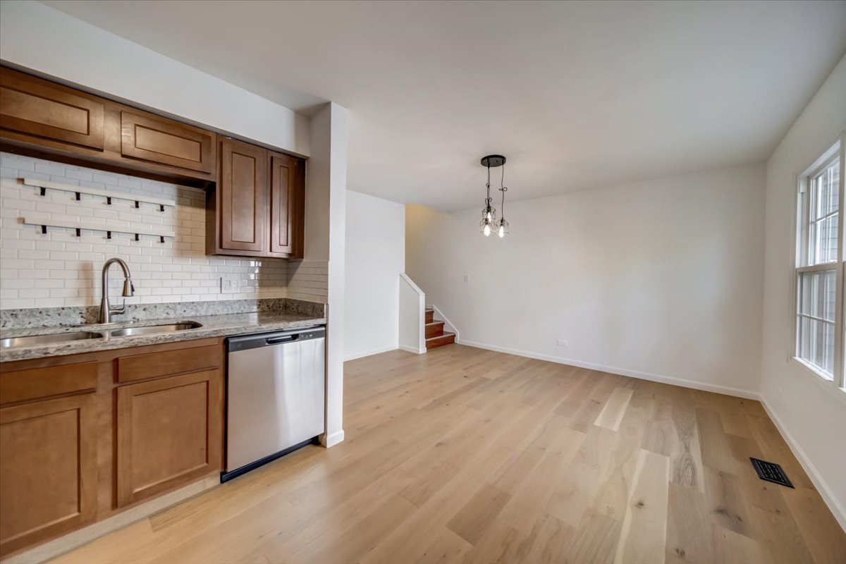 2414 West Harrison Street, Unit E Chicago, IL 60612 - Photo 11 of 37 a kitchen with granite countertop a sink stainless steel appliances and cabinets