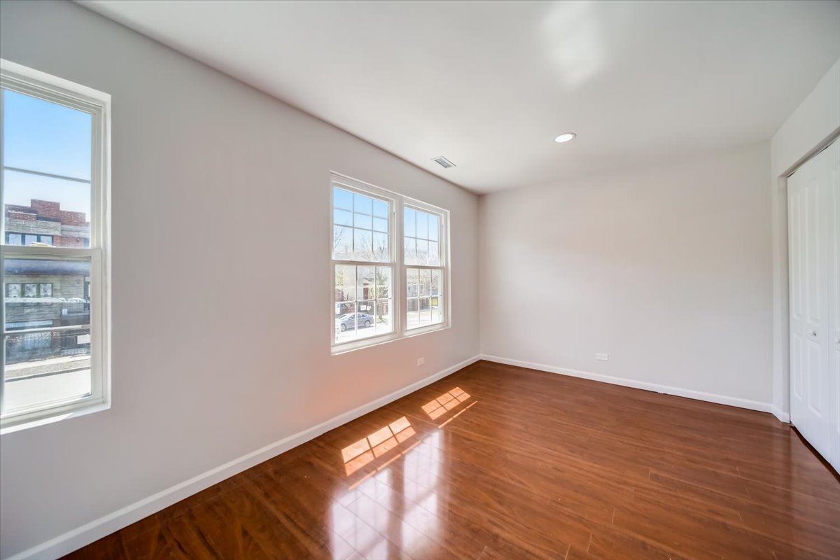 2414 West Harrison Street, Unit E Chicago, IL 60612 - Photo 14 of 37 a view of an empty room with wooden floor and a window