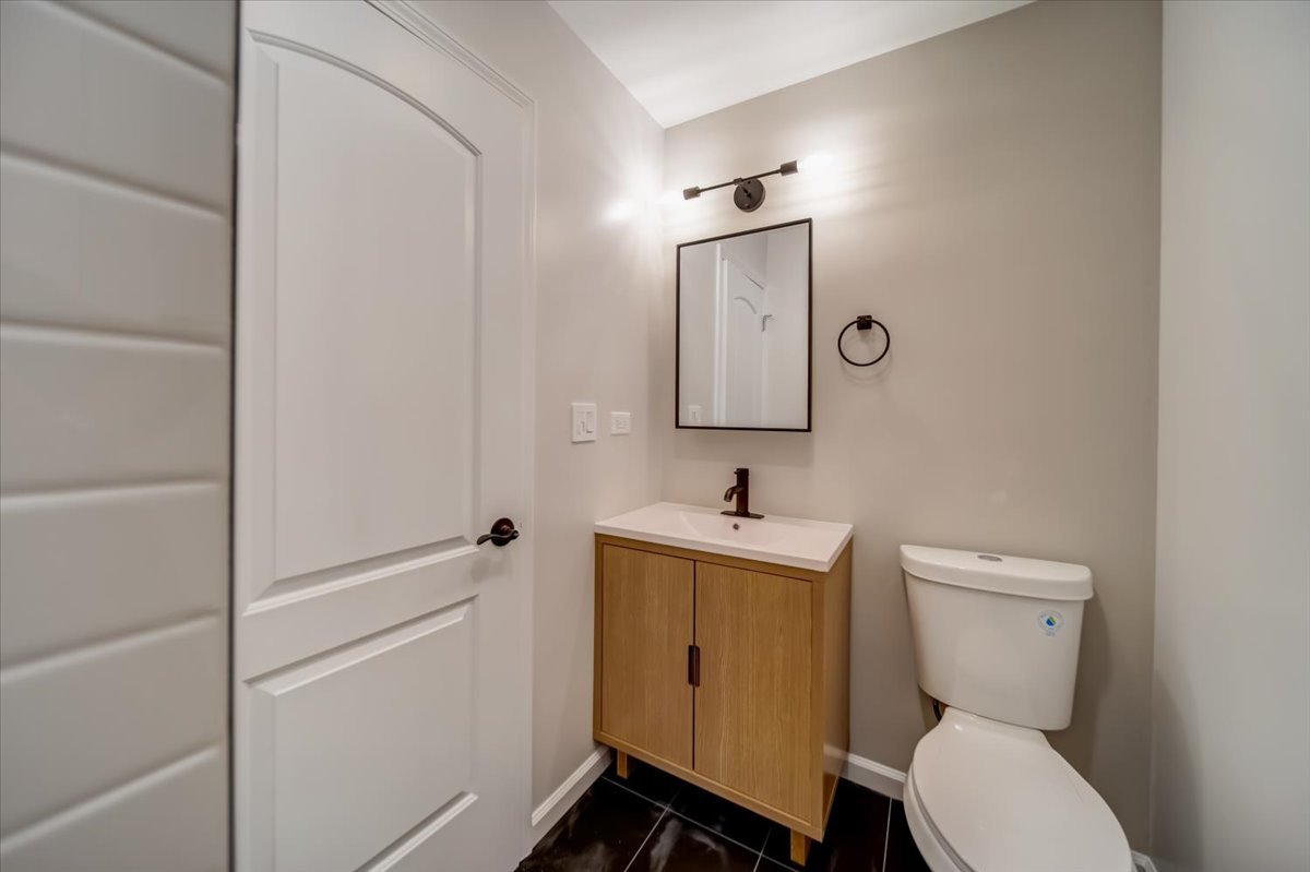 2414 West Harrison Street, Unit E Chicago, IL 60612 - Photo 15 of 37 a bathroom with a toilet a sink and mirror