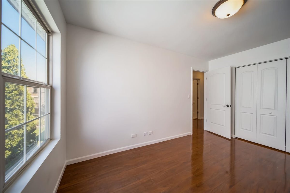 2414 West Harrison Street, Unit E Chicago, IL 60612 - Photo 18 of 37 a view of an empty room with wooden floor and a window