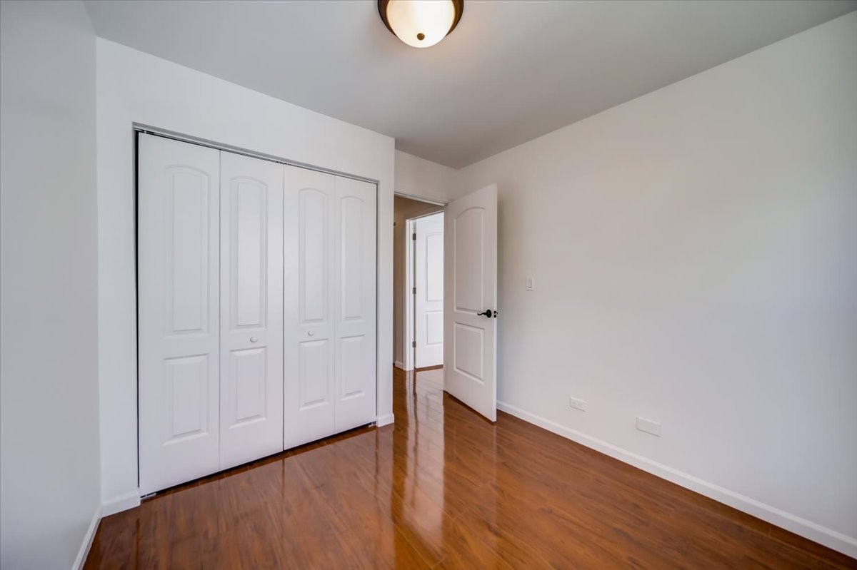 2414 West Harrison Street, Unit E Chicago, IL 60612 - Photo 24 of 37 a view of an empty room with wooden floor and a window