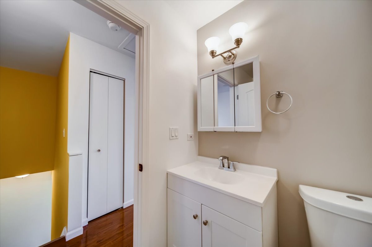 2414 West Harrison Street, Unit E Chicago, IL 60612 - Photo 28 of 37 a bathroom with a toilet a sink a mirror and vanity