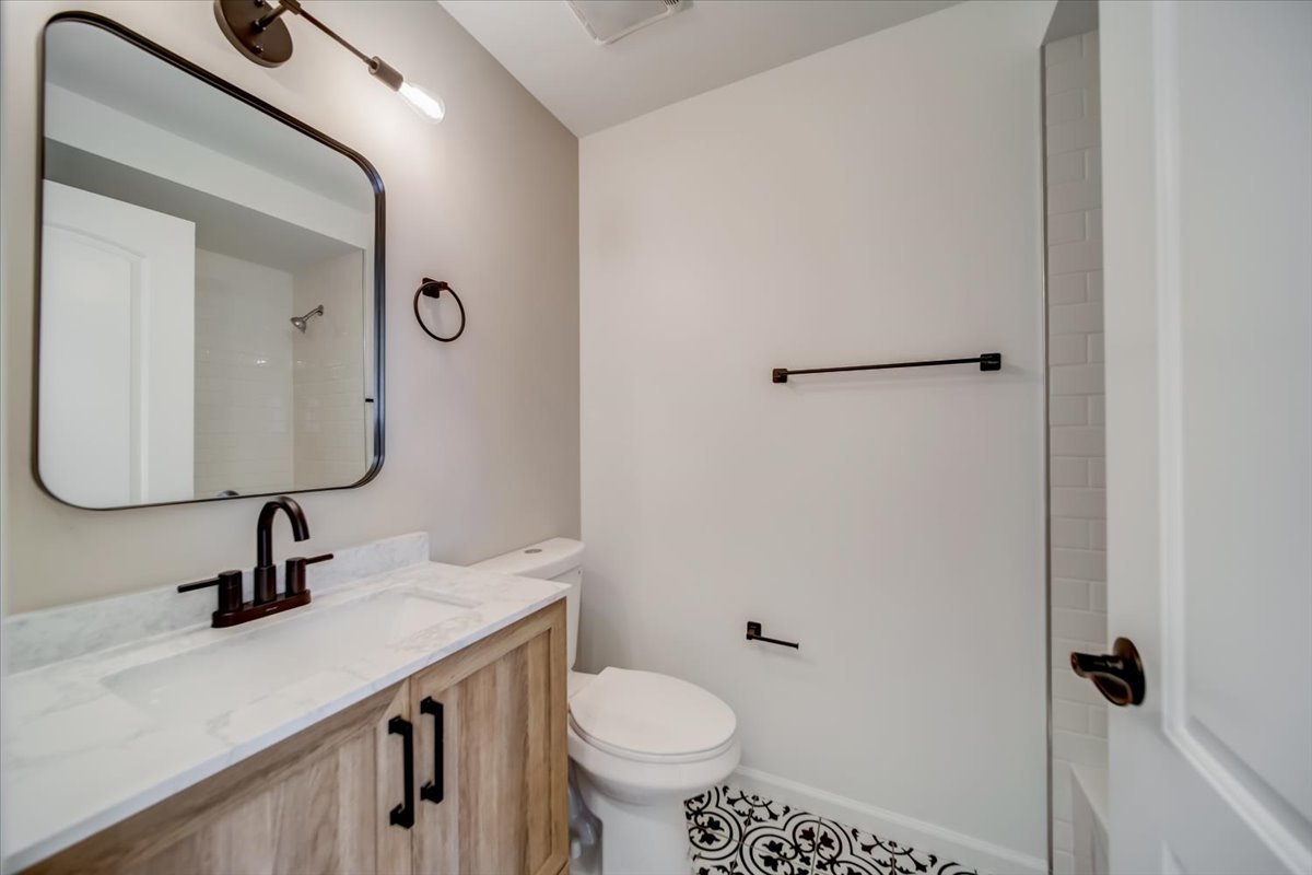 2414 West Harrison Street, Unit E Chicago, IL 60612 - Photo 6 of 37 a bathroom with a toilet sink and mirror