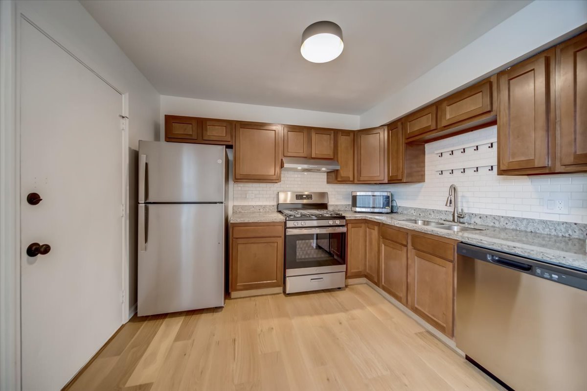 2414 West Harrison Street, Unit E Chicago, IL 60612 - Photo 10 of 37 a kitchen with granite countertop a refrigerator stove top oven and sink