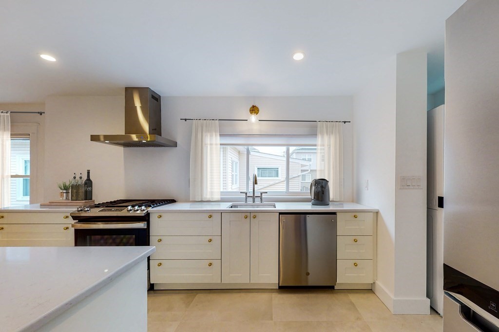 14 Olney Street, Unit 1 Watertown, MA 02472 - Photo 4 of 13 a kitchen with granite countertop a sink stainless steel appliances and cabinets