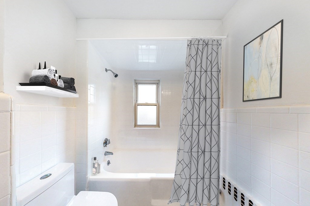 14 Olney Street, Unit 1 Watertown, MA 02472 - Photo 5 of 13 a bathroom with a bathtub a toilet and a shower