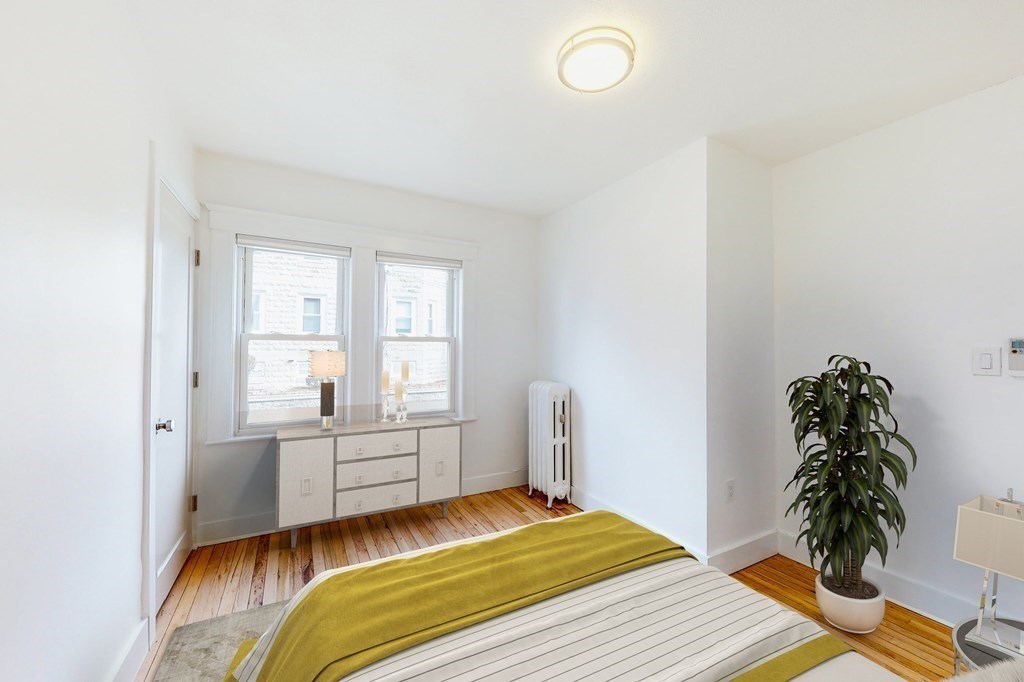 14 Olney Street, Unit 1 Watertown, MA 02472 - Photo 8 of 13 a bedroom with a bed and a potted plant