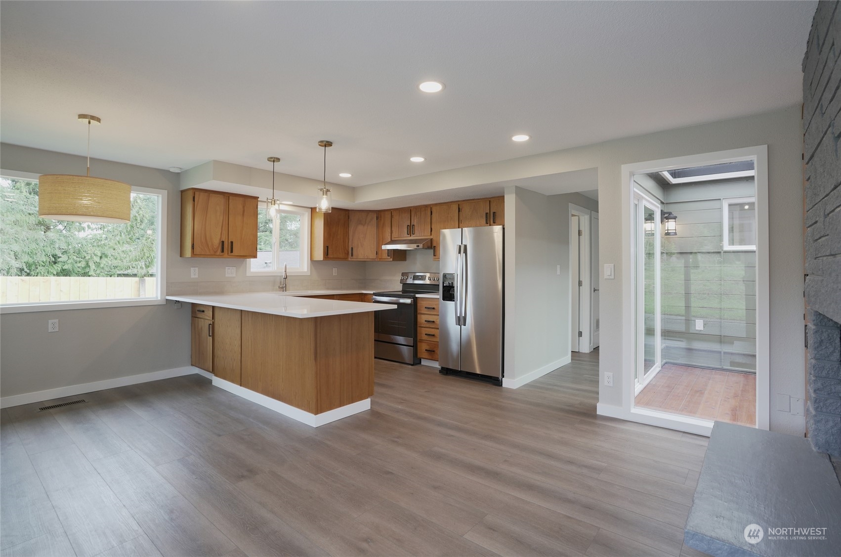 11012 Military Road Southwest Lakewood, WA 98498 - Photo 11 of 34 a kitchen with stainless steel appliances granite countertop a refrigerator a sink a stove a microwave and wooden floor